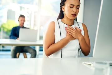 Woman with unexpected chest pains and heart issues in the office.