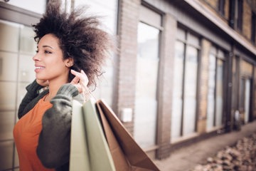 A woman holding many shopping bags after a stint of ADHD impulsivity and over-spending.