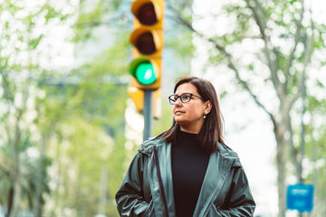 Woman on city walk by crossroad, getting more active with heart disease