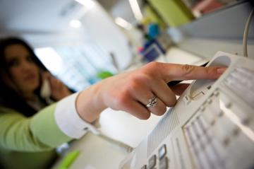 Woman hangs up her office landline due to phone call anxiety.
