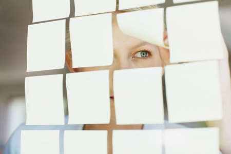 Woman with ADHD keeping organized with post-it notes on the window