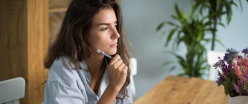 Woman with migraine writing down her daily list of achievements