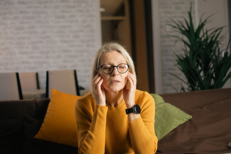 Female family caregiver sitting on couch and processing her conflicting feelings.