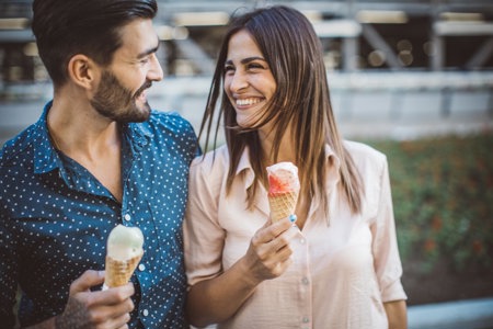 Happy couple eating ice cream cones, romance thriving despite the distractible symptoms that can come with ADHD