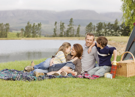 Happy family having picnic by the river, enjoying the weekend, despite migraine