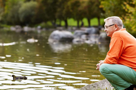 Man with heart failure by lake reflecting on his healthier lifestyle and mindset